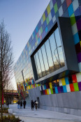 The Glass Mill Leisure Centre is situated on the lowest three floors of a 27 storey apartment building in Lewisham. The leisure centre includes 1400 glass panels in ten colours illuminated from behind. The lighting responds to the sounds outside of the centre. The new facility was designed by LA Architects and is managed by Fusion Lifestyle on behalf of Lewisham Council. The contractor for the project was Pellikaan, with additional work coming from Barratt Homes. The new centre features a 100-station fitness suite, a 25m, 8-lane swimming pool, a teaching pool, two group exercise studios, a rock climbing wall, a crèche, café and health suite, which includes a sauna, steam room, ice room and a relaxation area.